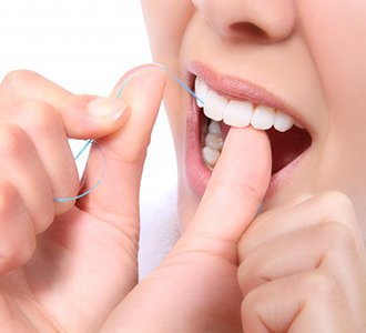 a person flossing for dental implant care