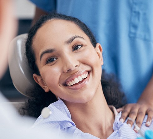 Woman smiling at dentist while sitting in treatment chair