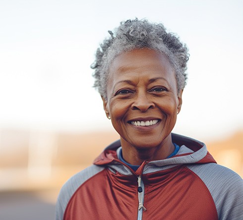 Older woman smiling after completing dental implant post-op instructions in Fort Valley