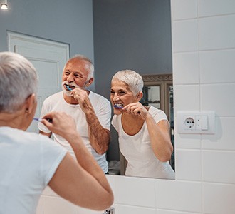 Older couple brushing their teeth